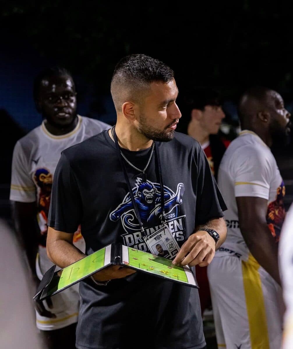 Coach Rafaz with a tactics clipboard on match night.